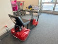 Motorized scooter with a grocery cart attached, getting charged. For customers with