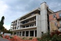 New hotel building under construction next to abandoned destroyed apartment building surrounded with construction material Royalty Free Stock Photo