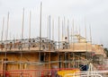 New house with brick wall is being erected and scaffold system placed around it to allow bricklayer to work