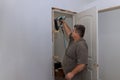 In a new house, an interior door is installed by a trim carpenter
