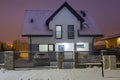 New house with stone fence at snowy night Royalty Free Stock Photo