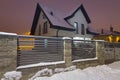 New house with stone fence at snowy night Royalty Free Stock Photo