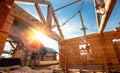 New house wooden log construction interior with exposed framing roof with sun light Royalty Free Stock Photo