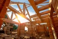 New house wooden log construction interior with exposed framing roof with sun light Royalty Free Stock Photo