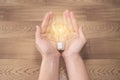 New idea concept, young women hand holding light bulb and coins on wooden backgrounds and new idea concept save power to save the. Royalty Free Stock Photo