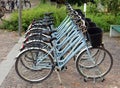 New identical blue women bicycles lined up on a sidewalk