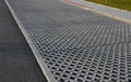 New infiltration parking lot made of porous concrete tiles in a regular square grid with holes filled with gravel. in connection w