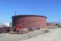 New installation crude oil storage tank with floating roof and a crane in the construction site. Royalty Free Stock Photo