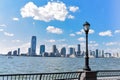 New Jersey skyline from Battery Park in a sunny day. Cityscape view through trees and streetlamp. City and travel concept. Royalty Free Stock Photo