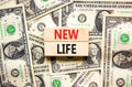 New life symbol. Concept words New life on wooden blocks on a beautiful background from dollar bills. Business, support, Royalty Free Stock Photo