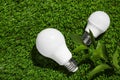 New light bulbs on fresh green grass, flat lay Royalty Free Stock Photo