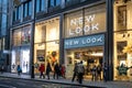 New Look big new clothes retail modern city centre store shop with brand logo and sign illuminated at night busy with tourists