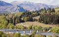 The New Lower Shotover Bridge, located in Queenstown, New Zealand, spans a peaceful river, set against a scenic