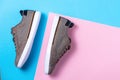 New male's stylish sneakers made of grey canvas on a pink-blue background. Flat lay. Copy space. Side view of shoes Royalty Free Stock Photo