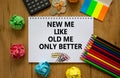 New me symbol. White note with words `new me like old me only better` on beautiful wooden table, colored paper, colored pencils,