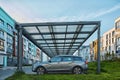 New Metal Carport for public vehicle parking in Front of Multi residential Building. outdoor parking lot with car Royalty Free Stock Photo