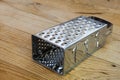 New metal grater on the old wooden table Royalty Free Stock Photo