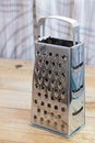 New metal grater on the old wooden table Royalty Free Stock Photo