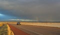 NEW MEXICO, USA - NOVEMBER 22, 2019: rainbow and car on the road during a red sunset and thunderclouds on the background of the Royalty Free Stock Photo
