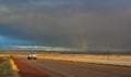 NEW MEXICO, USA - NOVEMBER 22, 2019: rainbow and car on the road during a red sunset and thunderclouds on the background of the Royalty Free Stock Photo