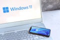 New Microsoft Windows 11 logo on computer screen and Windows 11 logo is seen on mobile phone screen. Royalty Free Stock Photo