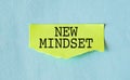 New mindset words letter, written on piece of memo paper, work desk top view. Motivational self development business typography