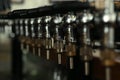 New modern beer taps in pub, closeup. Professional bar equipment Royalty Free Stock Photo