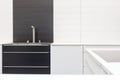 New modern black and white kitchen with chrome water tap and rectangular designer kitchen sink. Royalty Free Stock Photo