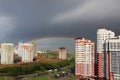 New modern block multistory house on dark sky background in four colors: red, orange, grey and white. Bad weather and rainbow. Royalty Free Stock Photo