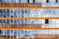 A new modern building of student dormitorie in the campus with many windows with reflections of blue sky with white clouds. Royalty Free Stock Photo