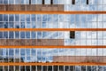 A new modern building of student dormitorie in the campus with many windows with reflections of blue sky with white clouds. Royalty Free Stock Photo