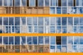 A new modern building of student dormitorie in the campus with many windows with reflections of blue sky with white clouds. Royalty Free Stock Photo