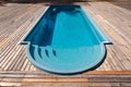 New modern fiberglass plastic swimming pool entrance step with clean fresh refreshing blue water on bright hot summer