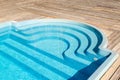 New modern fiberglass plastic swimming pool entrance step with clean fresh refreshing blue water on bright hot summer Royalty Free Stock Photo