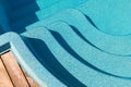 New modern fiberglass plastic swimming pool entrance step with clean fresh refreshing blue water on bright hot summer Royalty Free Stock Photo