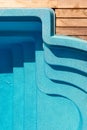 New modern fiberglass plastic swimming pool entrance step with clean fresh refreshing blue water on bright hot summer Royalty Free Stock Photo