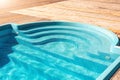 New modern fiberglass plastic swimming pool entrance step with clean fresh refreshing blue water on bright hot summer Royalty Free Stock Photo