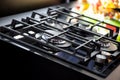 New modern gas stove with four burners for the kitchen, stainless steel surface. Cast iron grates. yellow background in Royalty Free Stock Photo