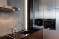 New modern kitchen with built in extractor hood, oven and chrome water tap. LED worktop illumination. Royalty Free Stock Photo