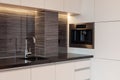 New modern kitchen with built in oven and chrome water tap. LED worktop illumination. Royalty Free Stock Photo