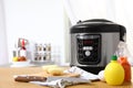 New modern multi cooker and products on table in kitchen Royalty Free Stock Photo