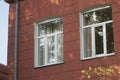 New modern multi-pack plastic window frames installed in an old shabby brick house. Combining technologies Royalty Free Stock Photo