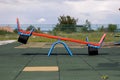 New modern plastic bright colorful blue and red empty toy seesaw swing on nursery playground with soft rubber flooring on bright s