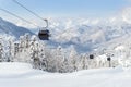 New modern spacious big cabin ski lift gondola against snowcapped forest tree and mountain peaks covered in snow Royalty Free Stock Photo