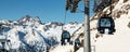 New modern spacious big cabin ski lift gondola pillar against snowcapped mountain peaks covered in snow landscape in Royalty Free Stock Photo