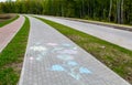 New modern tile sidewalk with chalk painted flowers near a road under construction