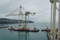 New modern very high gantry cranes transported on ponton and towed by two tugboats. Royalty Free Stock Photo