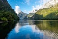 A new morning dawning at Doutful Sound, clouds hanging low in the mountains, Fiordland National Park, New Zealand