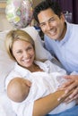 New mother with baby and husband in hospital Royalty Free Stock Photo