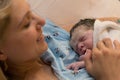 New mother happily holding her newborn child moments after labor Royalty Free Stock Photo